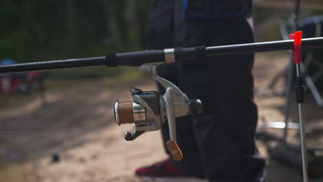 fisherman preparing and setting up fishing rods on riverbank