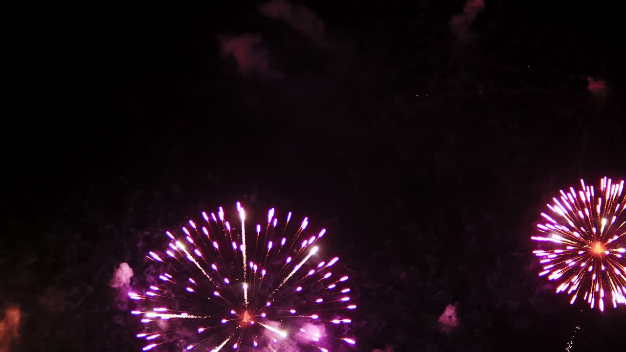 Colorful real fireworks display celebration in New year's eve with an abstract blur of golden shining with bokeh lights in the night sky