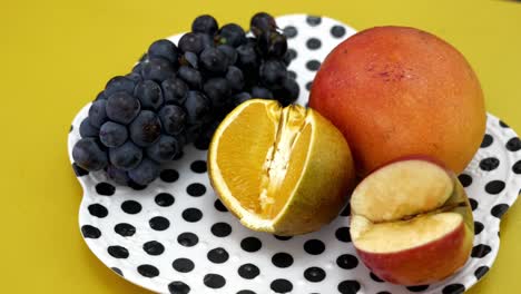 fruits in a plate mango, orange, apple, and berries