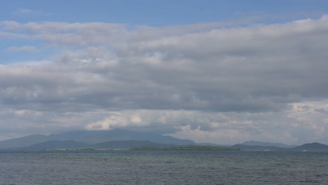 Bellas-Nubes-Blancas-Sobre-El-Mar-En-Calma-En-Dos-Palmas-Island-Resort-En-Puerto-Princesa,-Palawan,-Filipinas---Plano-Amplio