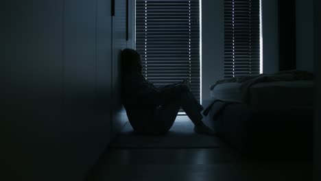 sad person sitting alone in bedroom