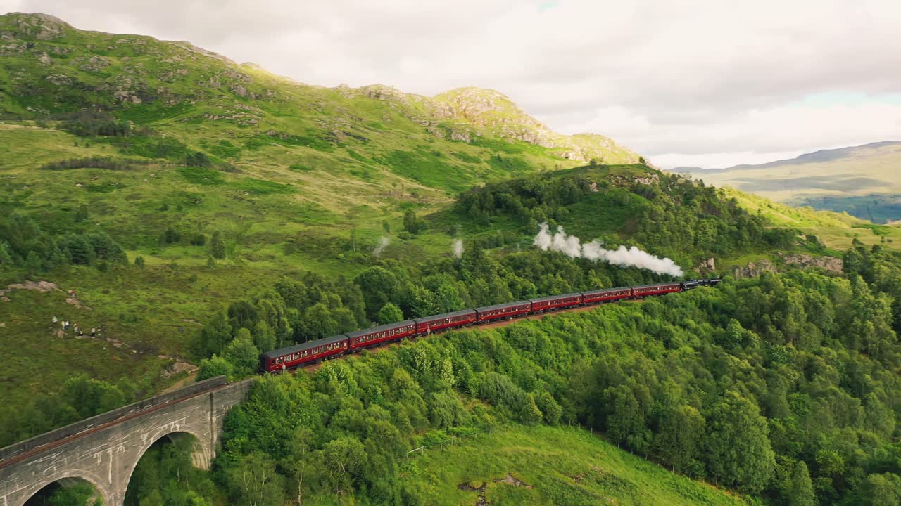 스코틀랜드 하이랜드 (scotland highlands) 에 있는 glenfinnan viaduct 철도 다리를 떠나는 유명한 jacobite 증기 열차 (jacobite steam train) 의 공중 사진.
