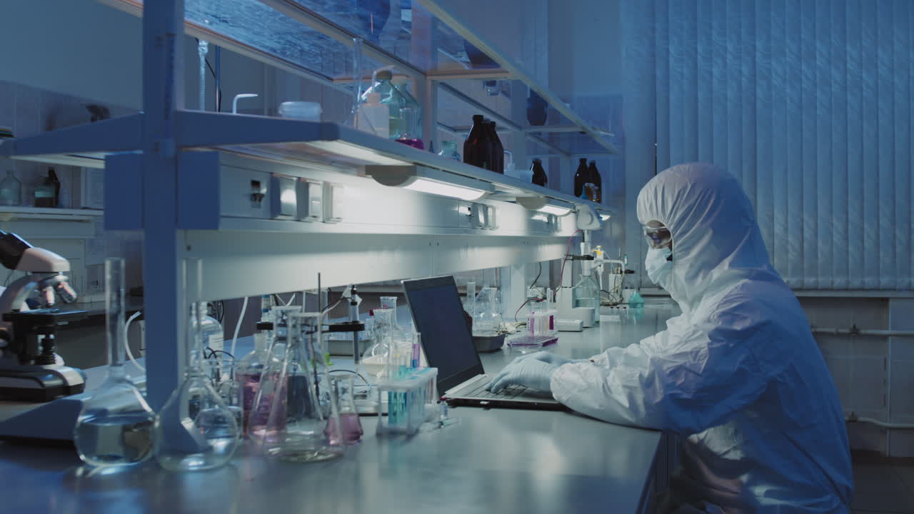 Scientists in Protective Coveralls Doing Research in Lab