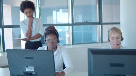 Female-call-center-mentor-and-operators-in-headsets