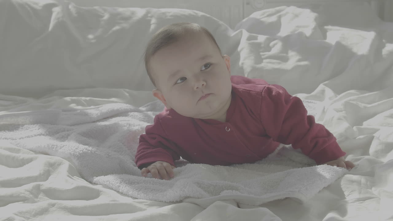 lindo bebé acostado en una cama acogedora