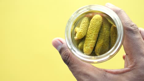 hand holding a jar of pickles