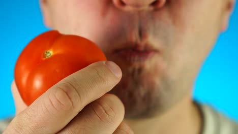 토마토를 고 먹는 남자. 남자 얼굴 하반기의 클로즈업, 채소를 먹는 남자