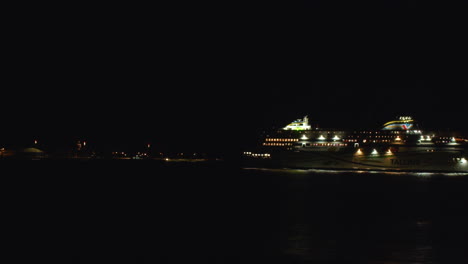 a large cruise ship docks at night with lights on