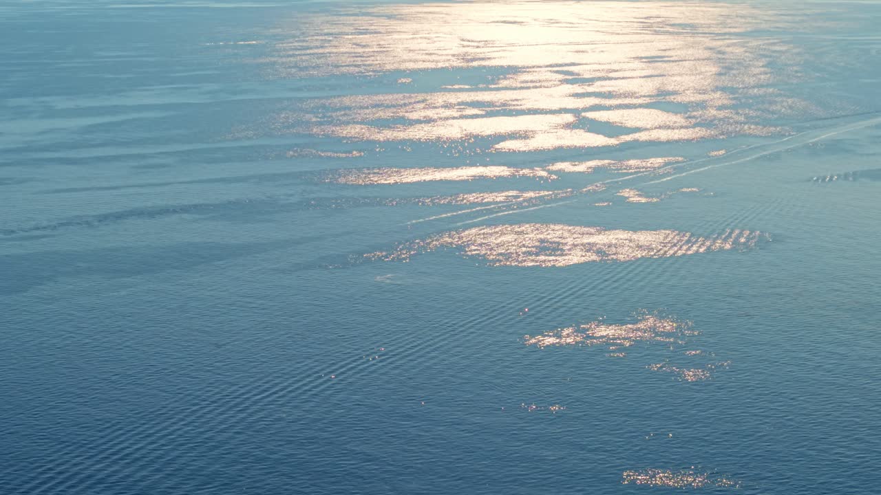Calm ocean waters with sunlight reflecting off the surface, italy, aerial view
