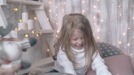 child with long blond hair plays with winter themed toys