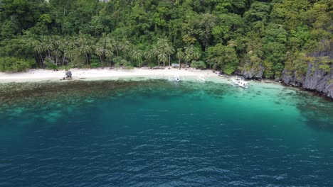 en un impulso aéreo sobre la playa de palmas tropicales de la bahía de pasandigan en la isla de cadlao en el nido