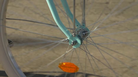 revolving front wheel of a turquoise bicycle