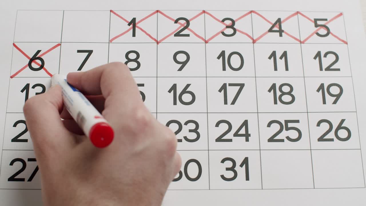 la mano del hombre escriba el día 6,7,8,9,10 en el calendario de papel usando un bolígrafo rojo