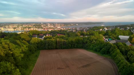 rising drone shot over norwegian town with houses, boats and sea in the background