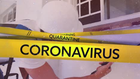 words warning quarantine coronavirus written on yellow tape over a man wearing a face mask in backgr