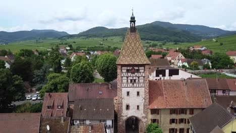 ujęcie wieży zegarowej w górę, ukazujące domy, ulice, łąki i całą wioskę