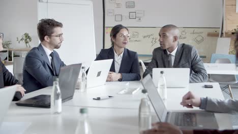 group of cheerful managers communicating during meeting