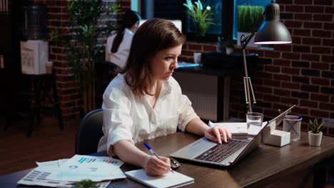 Businesswoman-in-brick-wall-office-focused-on-finishing-company-project