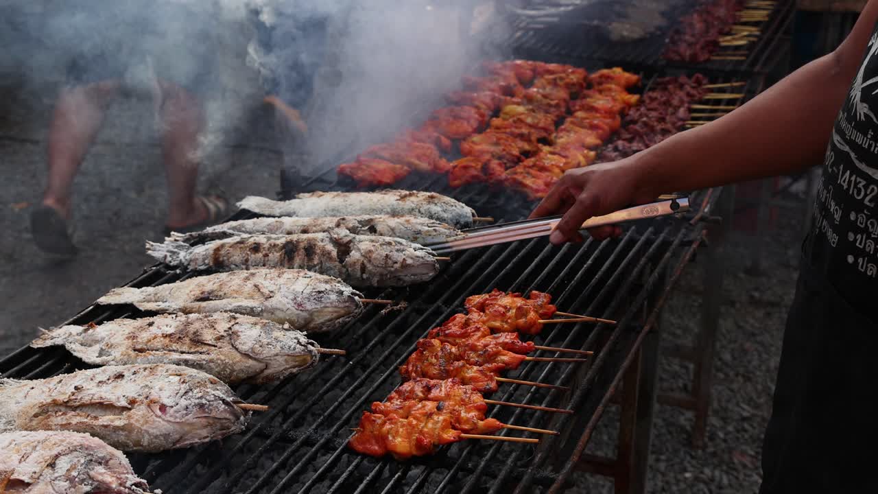 Grilling fish and skewers over charcoal flames.