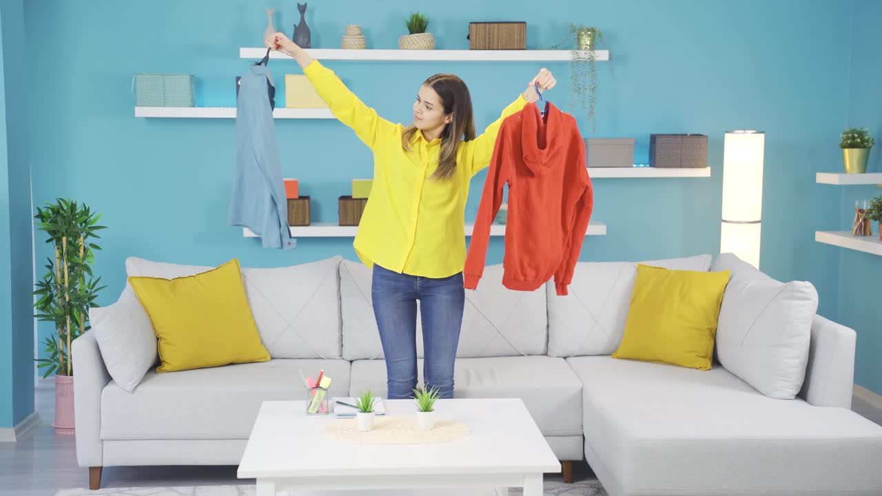 una chica joven tratando de gustarle la ropa.