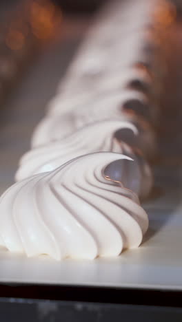Conveyor belt movement with white marshmallows. Close-up. Confectionery factory. Vertical video