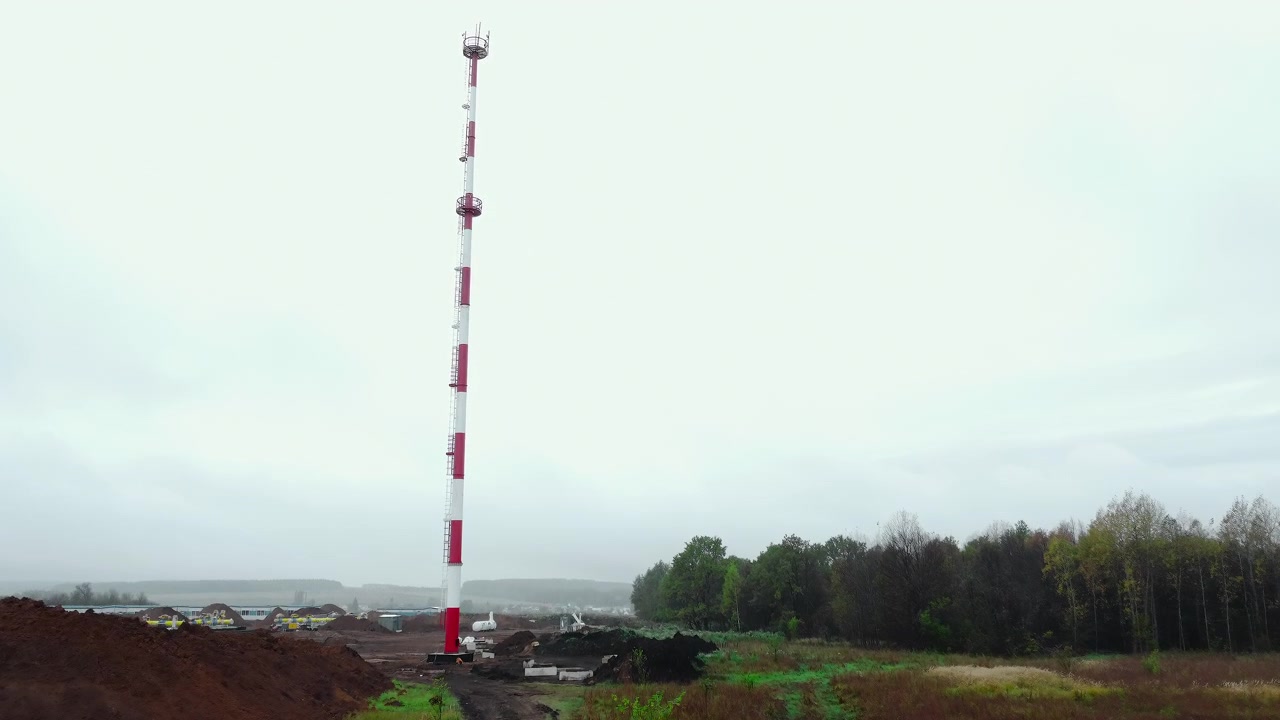 Vista aerea ascendente di un'alta torre di comunicazione in un campo rurale
