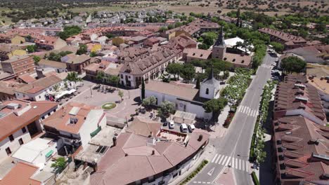 Aerial:-Santiago-Apóstol-Church-and-Plaza-de-Sevilla-in-Sevilla-de-la-Nueva,-Spain