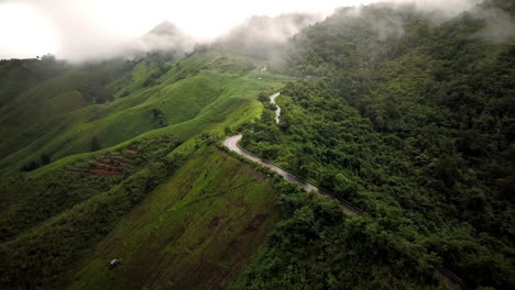 Vista-Aérea-Volando-Sobre-La-Exuberante-Montaña-Verde-De-La-Selva-Tropical-Con-Nubes-De-Lluvia-Durante-La-Temporada-De-Lluvias-En-El-Parque-Nacional-Reservado-De-La-Montaña-Doi-Phuka-En-El-Norte-De-Tailandia