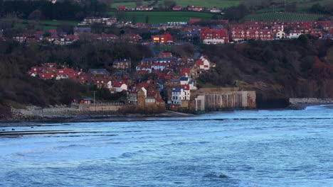 Establishing-Aerial-Shot-of-Robin-Hood's-Bay-over-Water-on-Winter-Morning