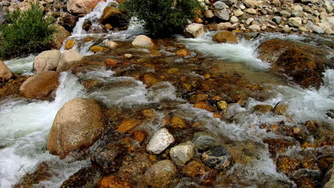 Video-En-Cámara-Lenta-De-Agua-Dulce-Corriendo-Río-Abajo,-A-Través-De-Rocas-Grandes-Y-Pequeñas