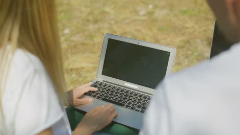vista parcial de una pareja usando computadoras portátiles al aire libre