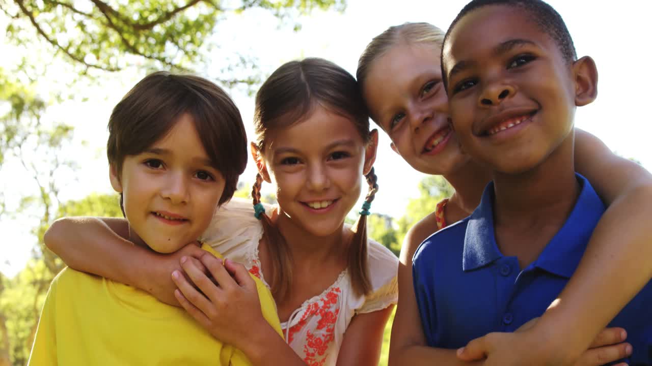 한 무리의 아이들이 팔을 고 함께 서 있습니다.