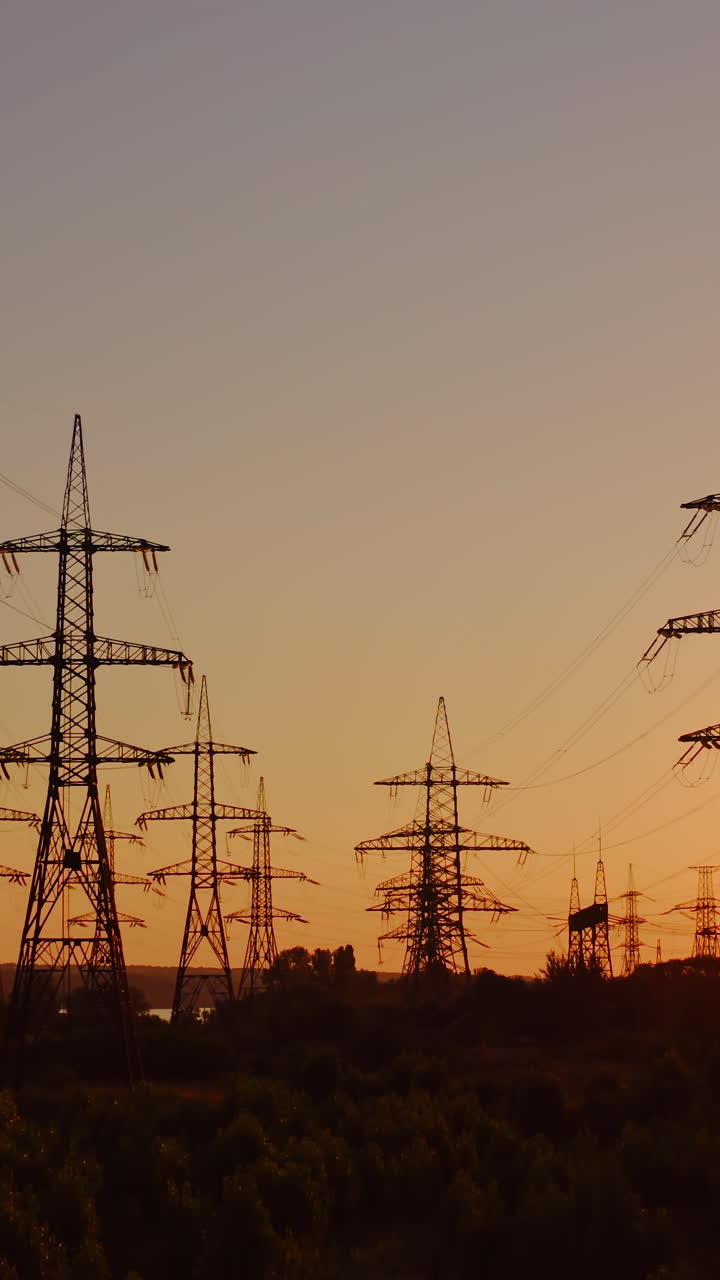 Wire electrical energy at sunset. High voltage electricity pole at sunset. Vertical video
