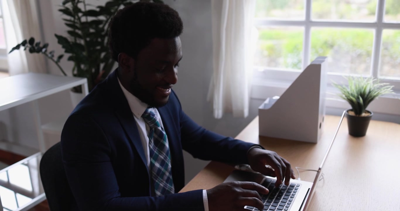 Professional Businessman Typing on Laptop in Bright Office