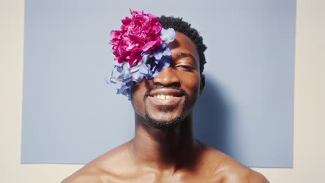 portrait of smiling black man wearing flower eyepatch