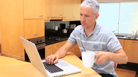 Smiling man typing on his laptop
