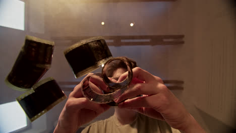 man interacting with film rolls through a glass surface