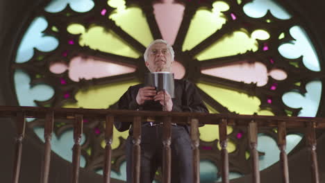 aged priest preaching sermon in christian church