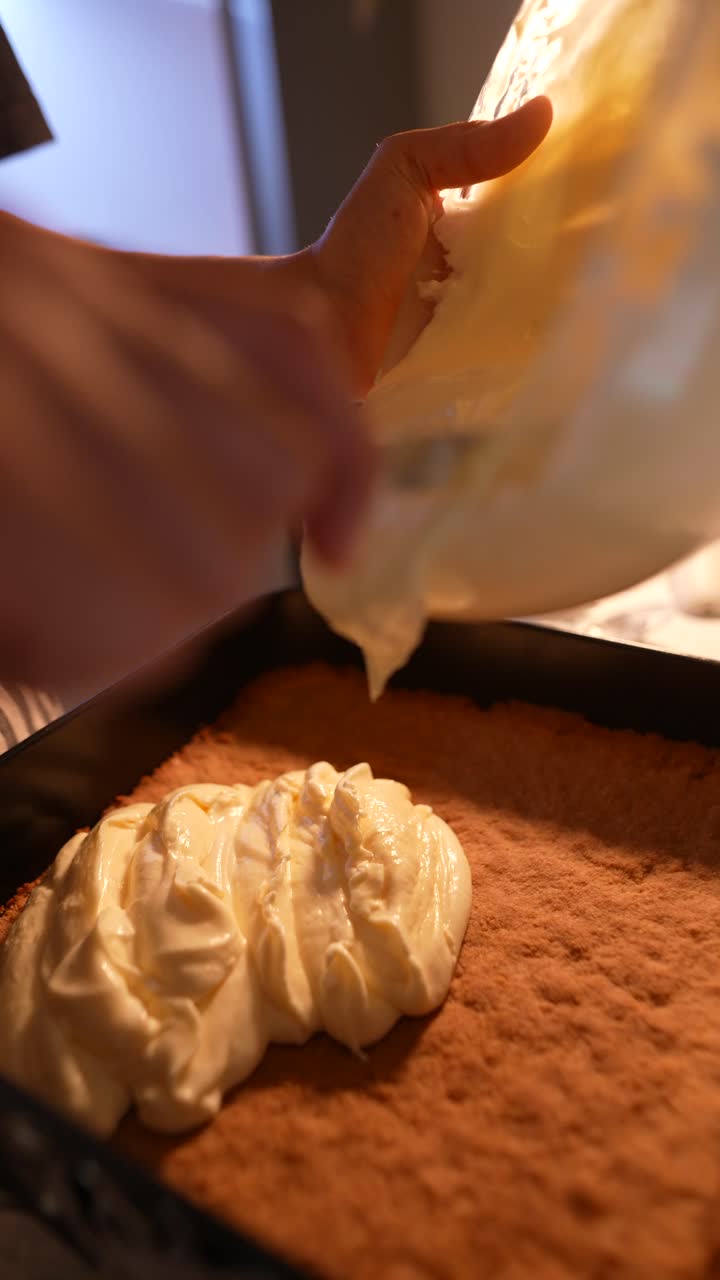 Close-up of Hands Pouring Creamy Filling onto Baked Dessert Base