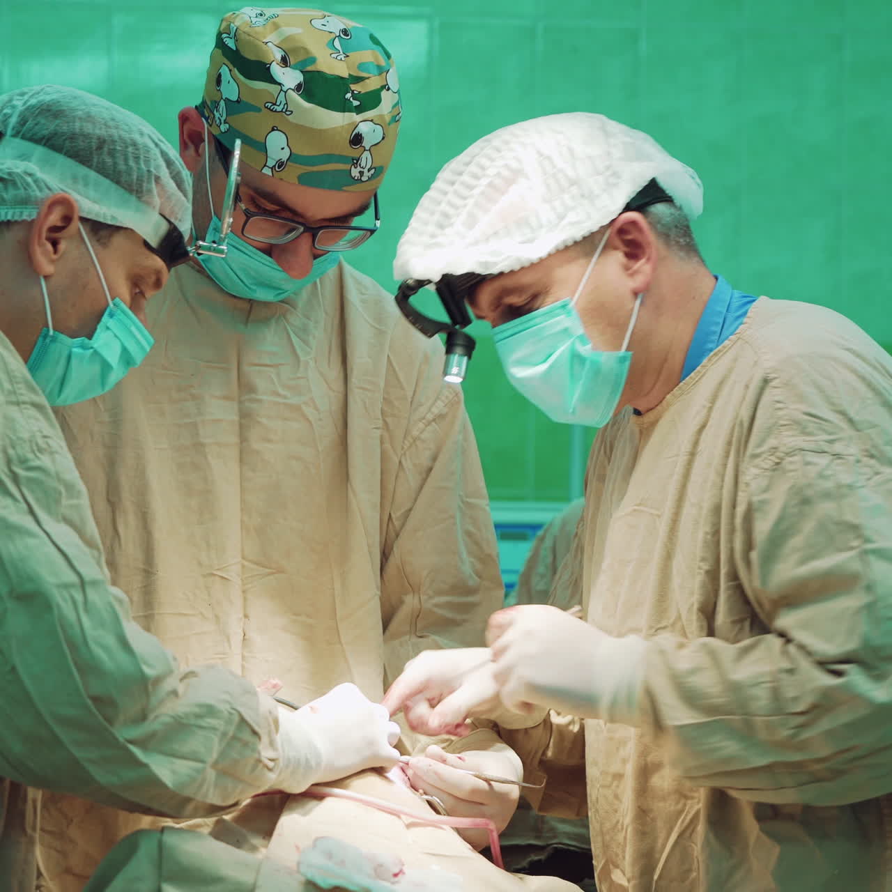 Group of surgeon specialists performing an operation on patient. Professional medical doctors during the operation process in operating room. Surgeons in medical uniform perform operation.