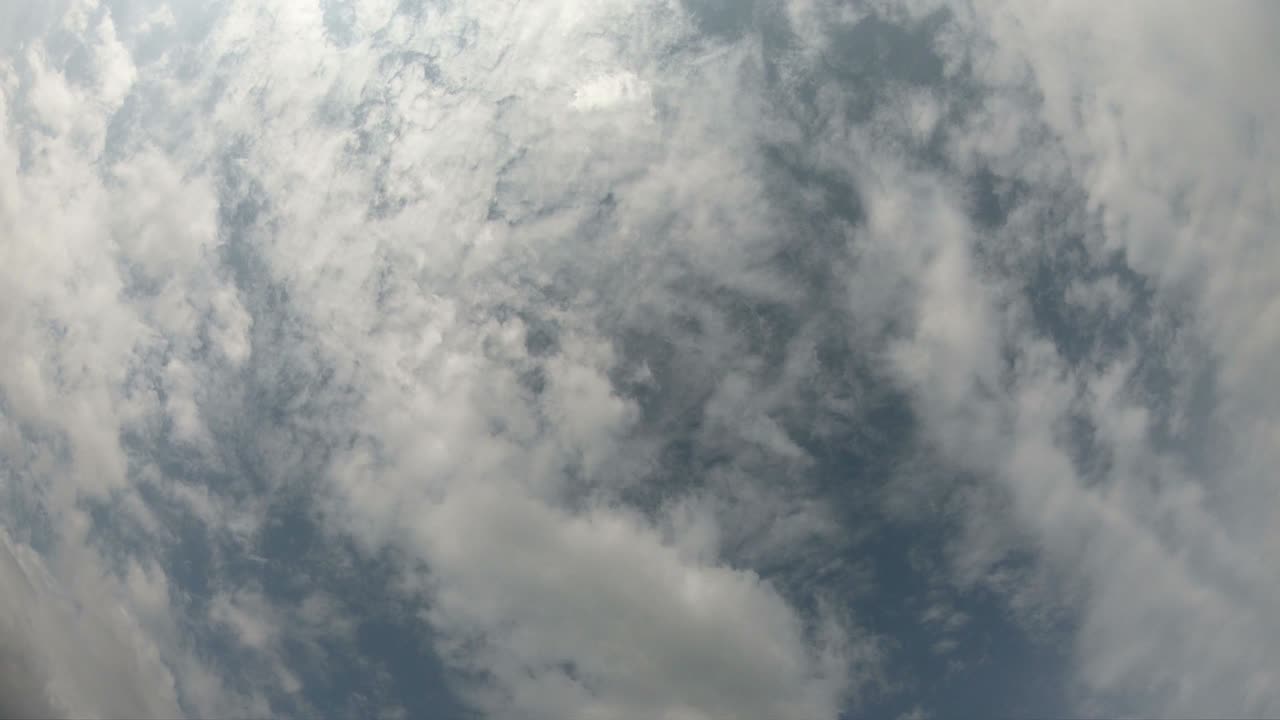 Time lapse of cloudscape with bright sun shining and revealing itself behind clouds.