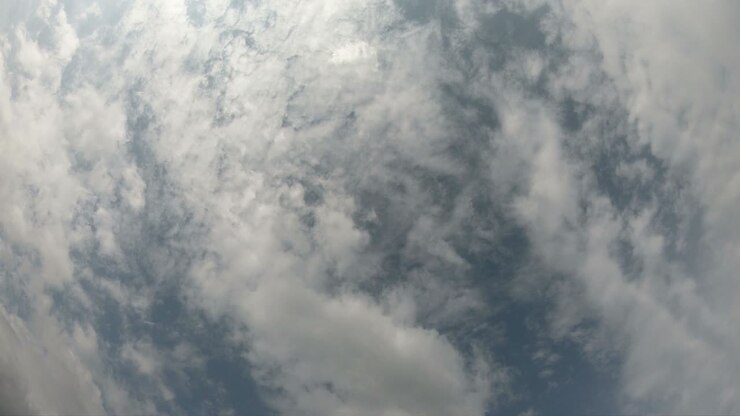Time lapse of cloudscape with bright sun shining and revealing itself behind clouds.