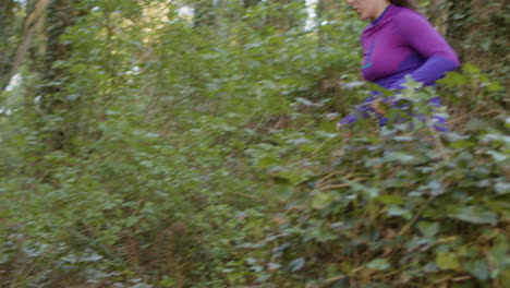 Fit-Caucasian-woman-running-in-forest