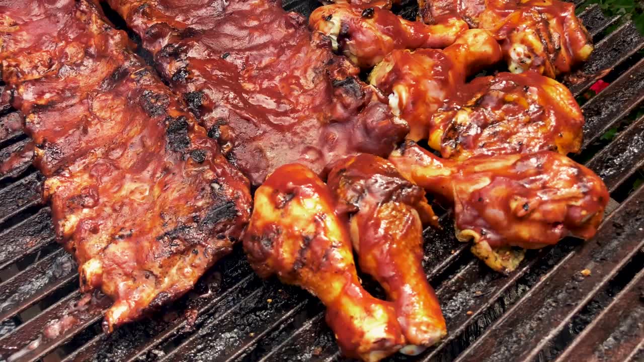 Some barbecue ribs and chicken on the grill.