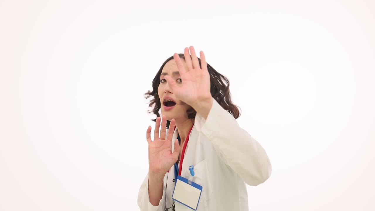 Scared female doctor raising hands in fear or defense