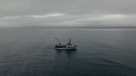 fishing trawler sailing under the overcast at the saint lawrence gulf in quebec, canada