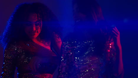 cerca de dos mujeres en un bar de club nocturno o discoteca bailando con luces brillantes 20