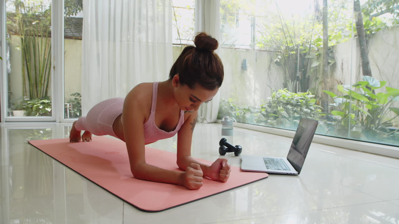 Woman Watching Video Tutorial on Laptop during Home Training