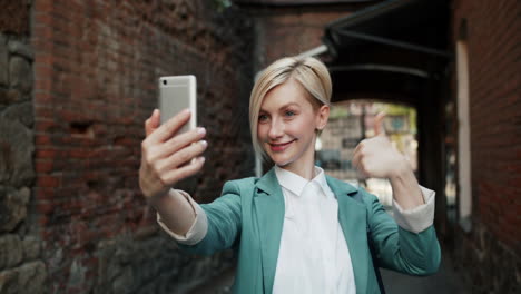 business woman taking selfie in city street