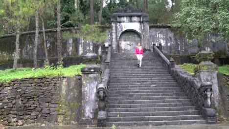 a woman descends the ancient stone staircase